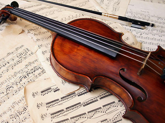 violín colocado sobre diferentes partituras